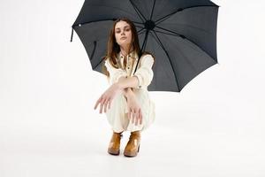 bonita mulher agachado aberto guarda-chuva moda moderno estilo foto
