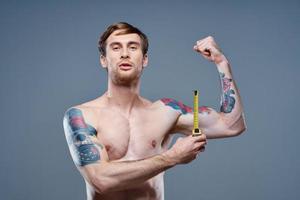 tatuado homem muscular fisiculturista ginástica cinzento fundo foto