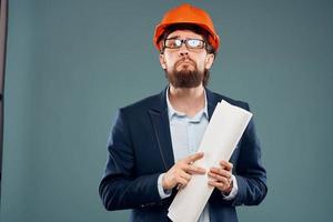 masculino engenheiro profissional laranja Difícil chapéu segurança construção plantas dentro mãos foto