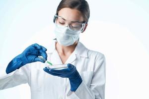 laboratório assistente dentro uma branco casaco médico mascarar pesquisa análises foto