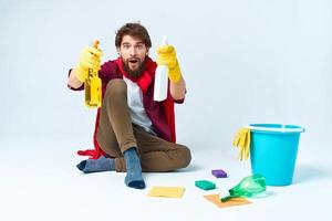 uma homem dentro uma vermelho capa de chuva sentado às casa lavando a pavimentos fornecendo Serviços trabalhos foto