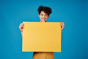 alegre cara com amarelo fósforo em uma azul fundo cópia de espaço foto