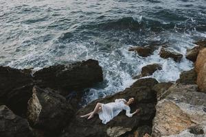 mulher dentro branco Casamento vestir em mar costa molhado cabelo Visão a partir de acima foto