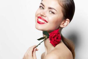 mulher com rosa Largo sorrir vermelho lábios charme nu ombros charme luz foto