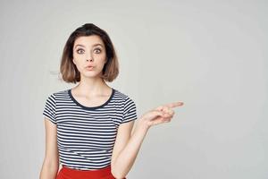 bonita mulher dentro uma listrado camiseta vermelho saia moderno estilo Penteado foto