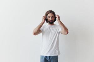 à moda homem dentro uma branco camiseta com sem fio fones de ouvido dentro dele orelhas tendo Diversão ouvindo para música sorrir em uma branco fundo estilo de vida foto