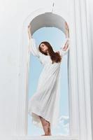 bonita mulher dentro uma janela abertura dentro uma branco vestir moda foto