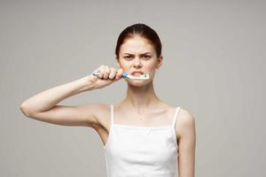 bonita mulher dentro branco camiseta dental higiene saúde Cuidado luz fundo foto