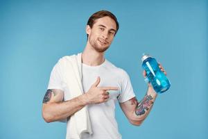 bonito homem dentro branco camiseta esporte água garrafa saúde exercite-se estilo de vida foto