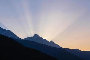 raios do Aumentar Sol atrás montanha dentro Himalaia, Índia foto