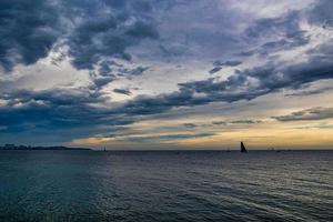 beira-mar panorama com nuvens e barco a vela em a horizonte alicante Espanha foto