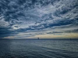 beira-mar panorama com nuvens e barco a vela em a horizonte alicante Espanha foto