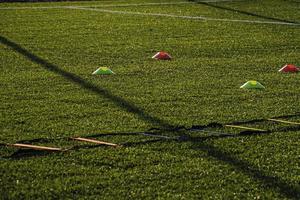 Treinamento futebol arremesso com artificial verde Relva e Treinamento Auxilia iluminado de a tarde Sol foto