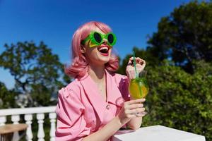 retrato do lindo mulher com Rosa cabelo verão coquetel refrescante beber feliz fêmea relaxante foto