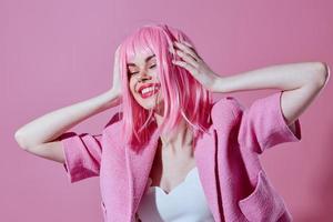 bonita jovem fêmea Rosa Jaqueta segurando cabelo cosméticos Rosa fundo inalterado foto