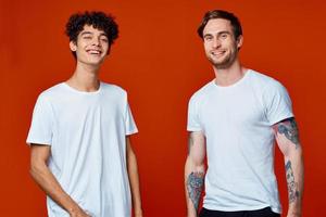 dois homens dentro branco Camisetas em uma vermelho fundo amizade foto