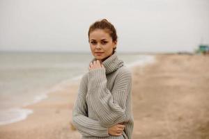 bonita mulher dentro uma suéter de a oceano turismo relaxamento conceito foto