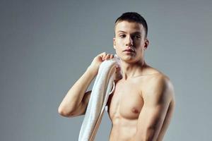 desportivo homem atraente Veja muscular corpo toalha em ombros isolado fundo foto