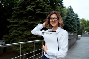 bonita o negócio mulher ao ar livre com documentos trabalhos foto