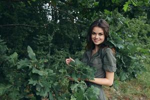 mulher dentro a floresta sorrir verde folhas viagem fresco ar foto