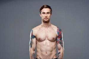 desportivo homem com tatuagens em dele braços exercite-se cortada Visão foto