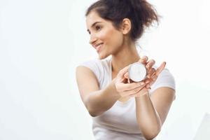 mulher dentro branco camiseta creme jarra pele Cuidado hidratante dermatologia foto