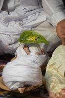 hindu adoração e ritual elementos fechar-se foto. hindu Casamento decoração com branco tecido e uma betel folha. noivo sentado dentro frente do alguns hindu puja elementos. tradicional hinduísmo Casamento conceito. foto