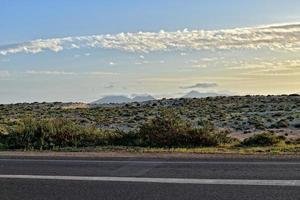 Largo asfalto estrada em a espanhol canário ilha fuerteventura com Palma árvores foto