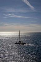 mar panorama em uma ensolarado dia com azul céu e água e uma Navegando navio foto