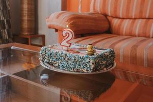 colorida saboroso bolo para a segundo aniversário com uma abelha e uma vela foto