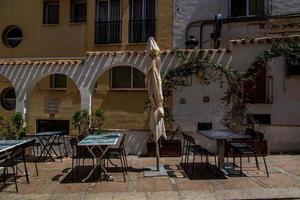 eu urbano panorama do uma espanhol rua dentro Benidorm com uma cafeteria e mesas em a calçada sem pessoas foto