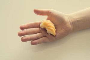 saboroso pequeno Páscoa Bolinho em uma criança mão em uma luz fundo foto