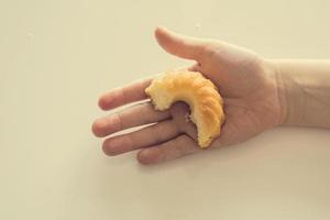 saboroso pequeno Páscoa Bolinho em uma criança mão em uma luz fundo foto