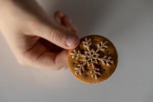 eu saboroso Pão de gengibre com branco floco de neve decoração para Natal manteve dentro a mão do uma chil foto