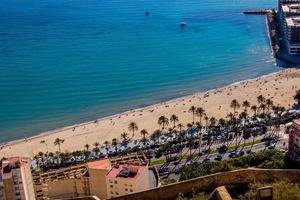 panorama a partir de acima em a praias do playa del postiguet em uma ensolarado dia areia água pessoas lazer foto