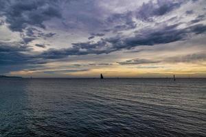 beira-mar panorama com nuvens e barco a vela em a horizonte alicante Espanha foto