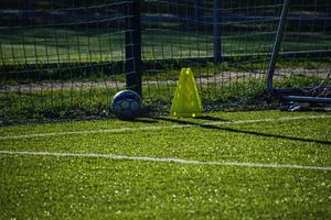 Treinamento futebol arremesso com artificial verde Relva e Treinamento Auxilia iluminado de a tarde Sol foto