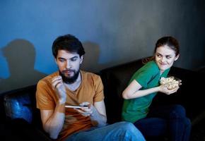 emocional homem e mulher assistindo televisão dentro de casa foto