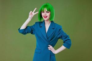 positivo jovem mulher vestindo uma verde peruca azul Jaqueta posando cor fundo inalterado foto