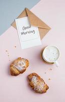 plano deitar composição com copo do café, croissants e cartão postal com texto Boa manhã foto
