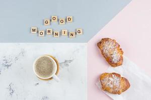 Boa manhã café da manhã mínimo conceito. copo do café, croissant, texto Boa manhã em fundo foto