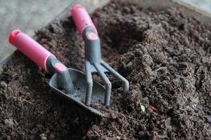 close-up de ferramentas de jardinagem no solo fértil foto