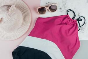 mulher de praia acessórios 1 peça roupa de banho, oculos de sol e chapéu em fundo foto