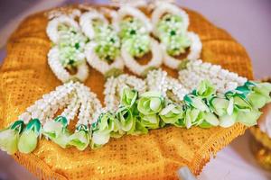 closeup de guirlandas florais para a noiva e o noivo em casamento tradicional tailandês foto