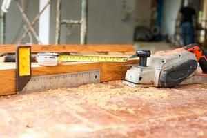 foco seletivo em ferramentas de carpintaria na mesa de madeira suja com serragem foto