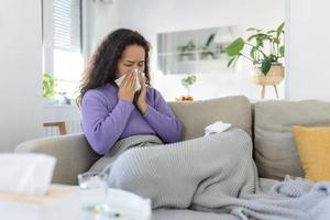 doente desesperado mulher tem gripe. rinite, frio, doença, alergia conceito. ásia doente mulher tem correndo nariz, esfrega nariz com lenço. espirros fêmea. morena espirros dentro uma lenço de papel foto