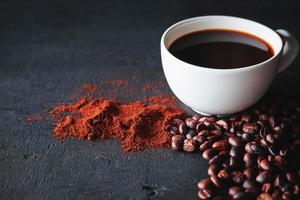xícara de café com grãos e café moído foto