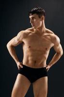 masculino atleta Sombrio covarde musculoso corpo estúdio Sombrio fundo foto