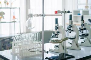 Ciência laboratório, microscópio e teste tubos em a trabalhando mesa química laboratório, cientista teste tubo com amostras foto