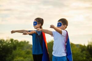 Super-heróis crianças amigos tendo Diversão ar livre, irmão e irmã jogando ao ar livre, Garoto e menina jogando ao ar livre foto